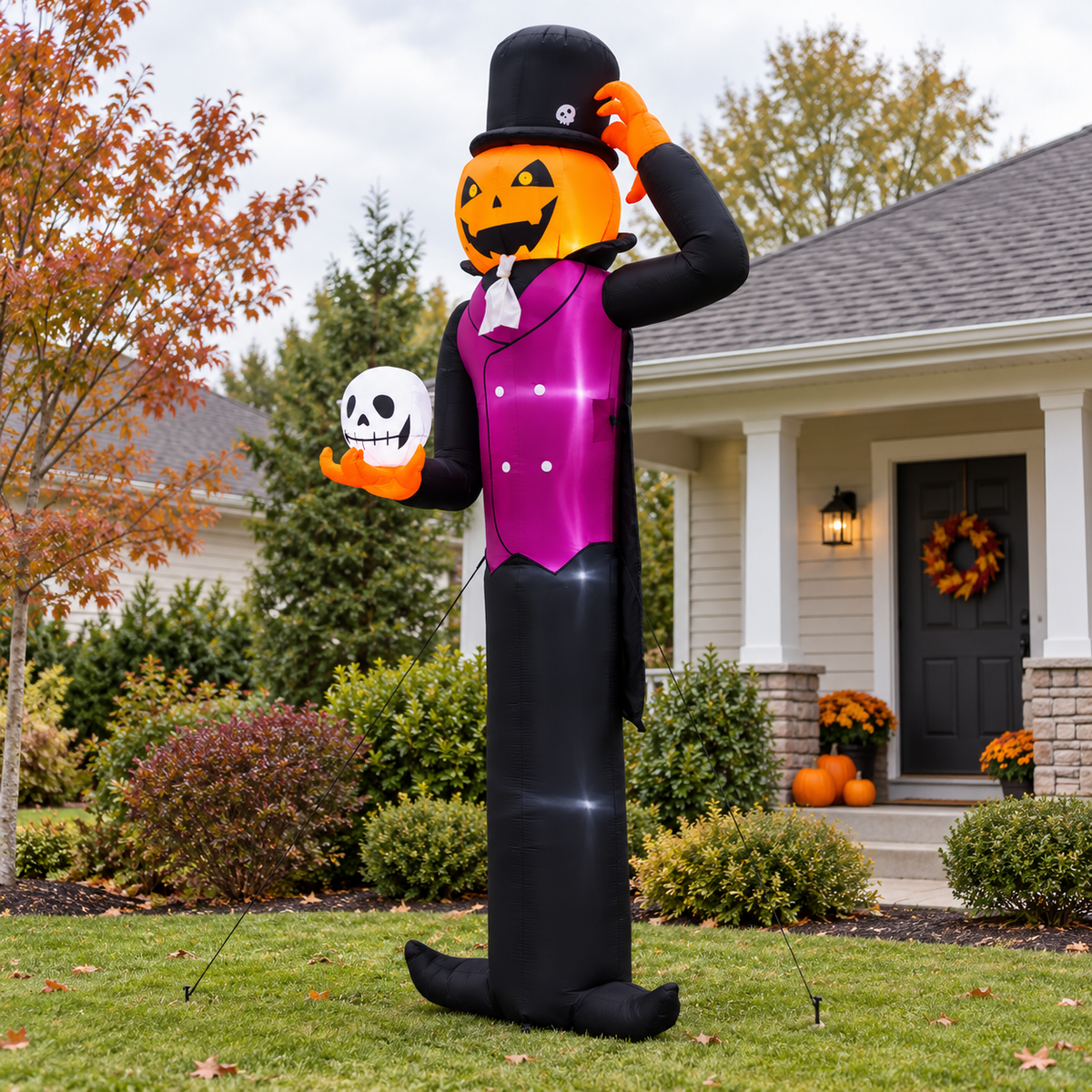 12-foot pumpkin man inflatable secured with stakes in a front yard during daylight