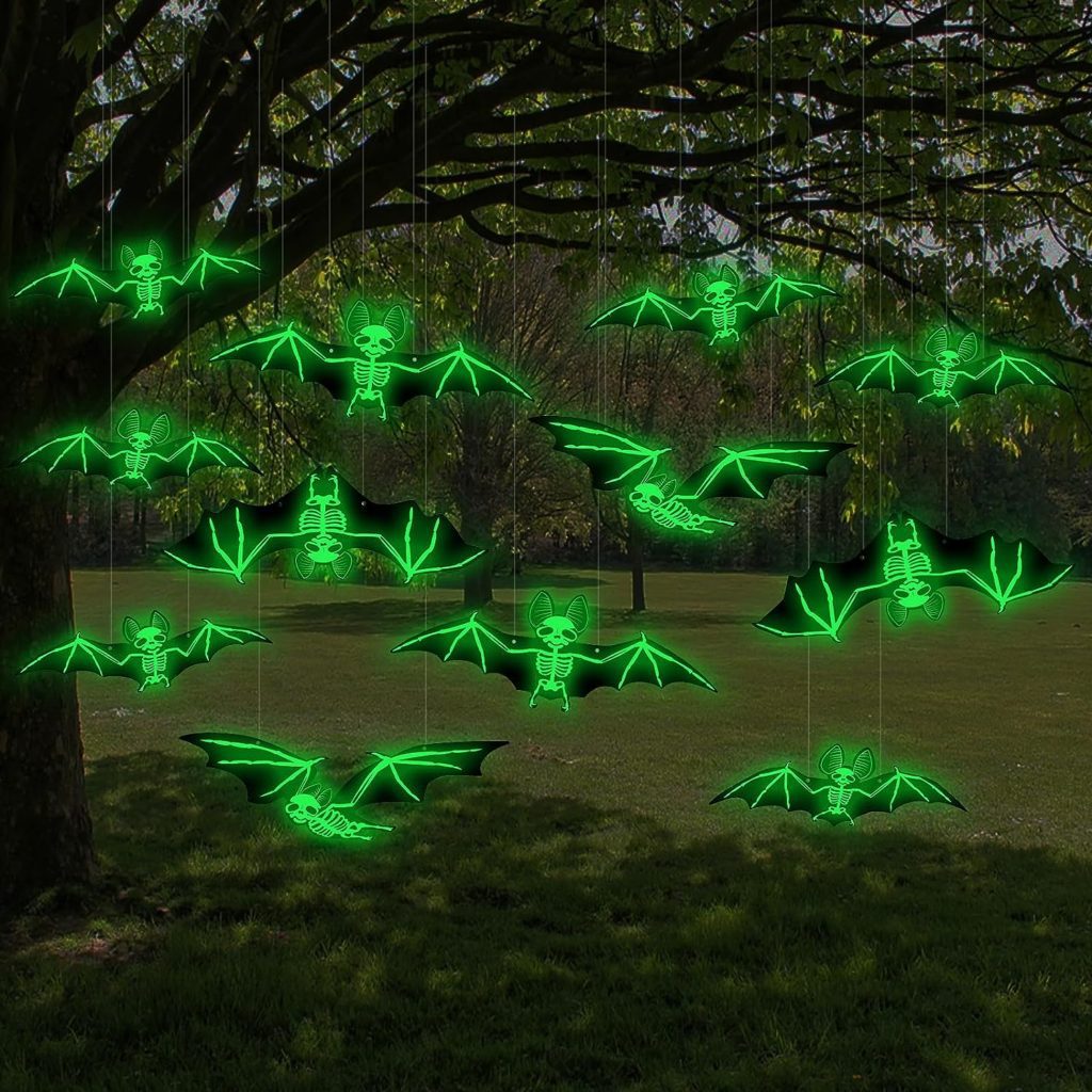 Glowing skeleton bats suspended from tree branches outdoors